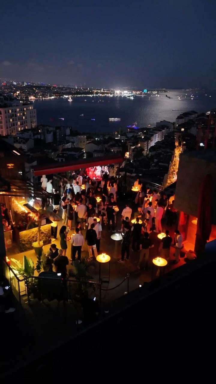 A lively Istanbul rooftop with a night view